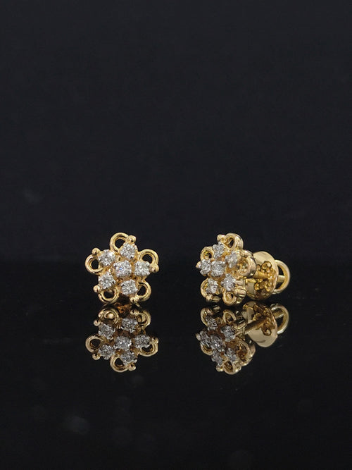 Pair of gold earrings with diamond stones 14K on black background
