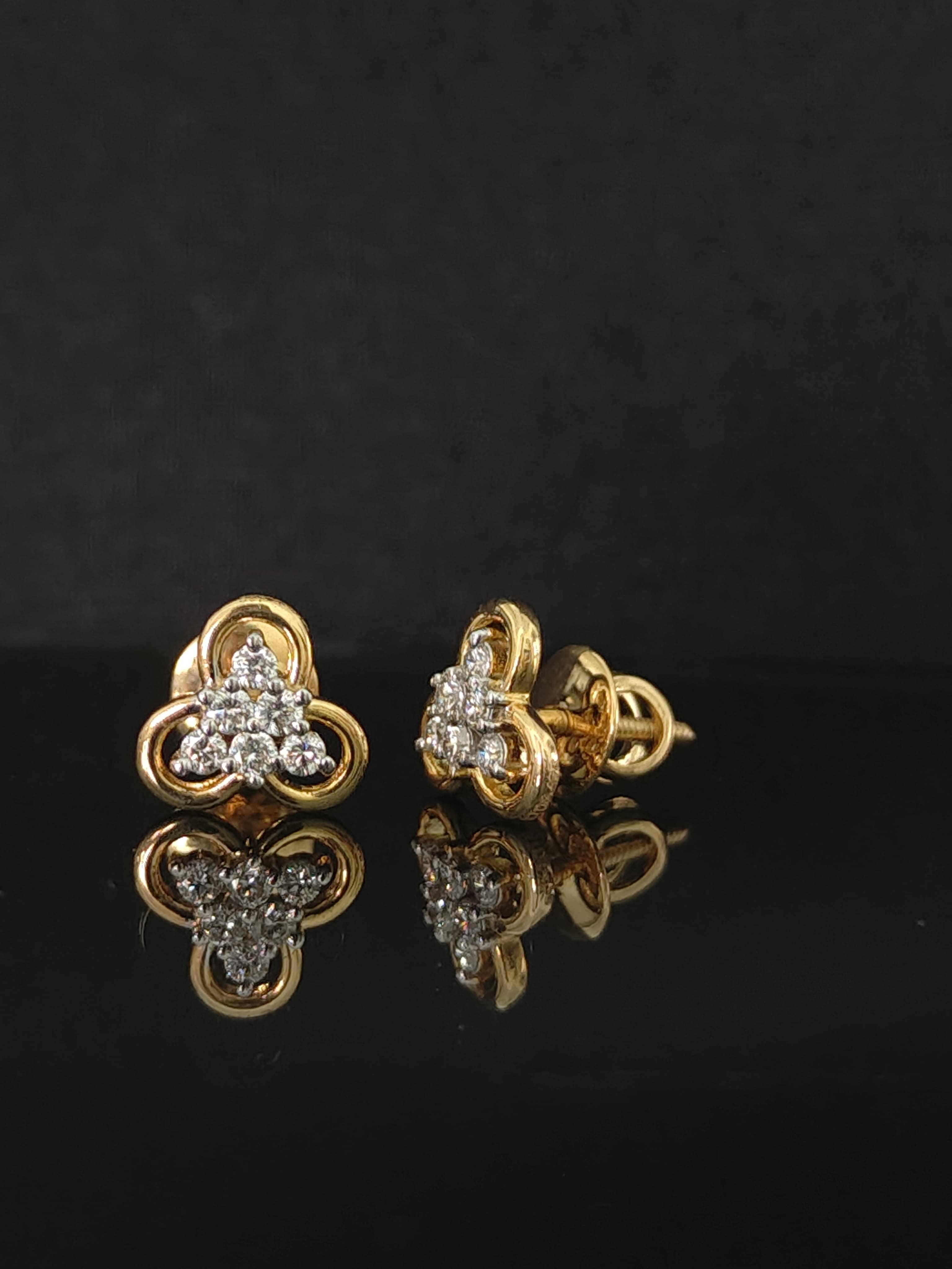 Pair of gold earrings with diamond accents 14K on black background
