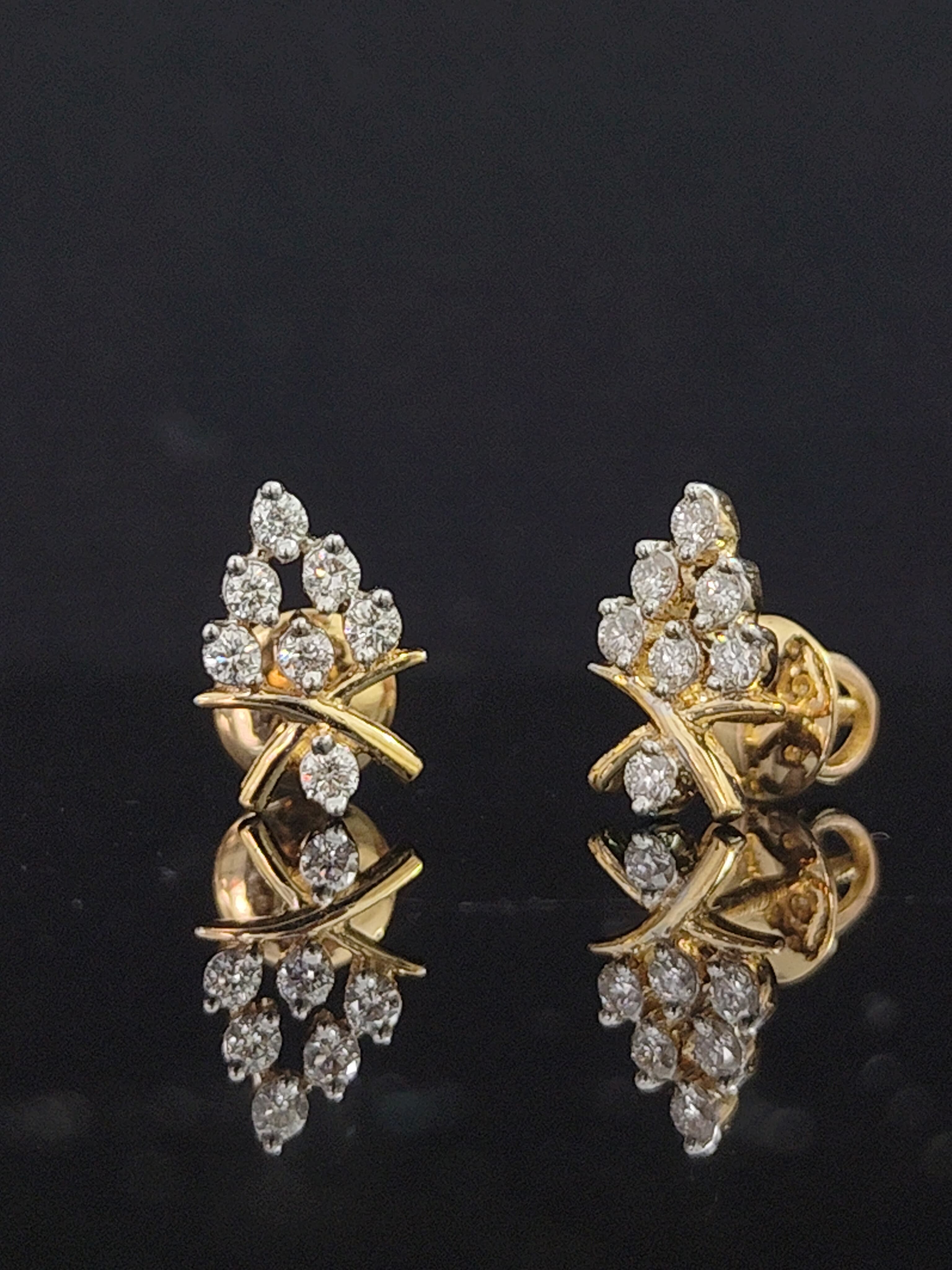 Pair of gold earrings with 0.25 carat diamonds 14K on black background