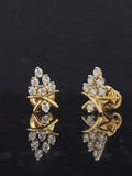 Pair of gold earrings with 0.25 carat diamonds 14K on black background

