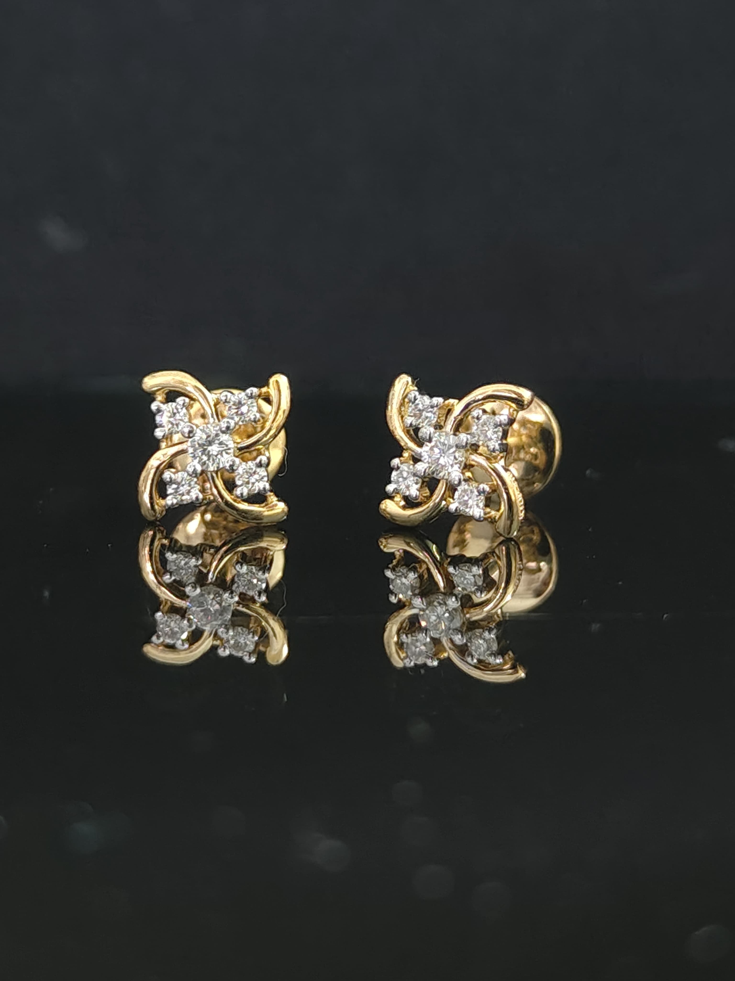 Pair of gold earrings with 0.2 carat diamonds 14K on black background
