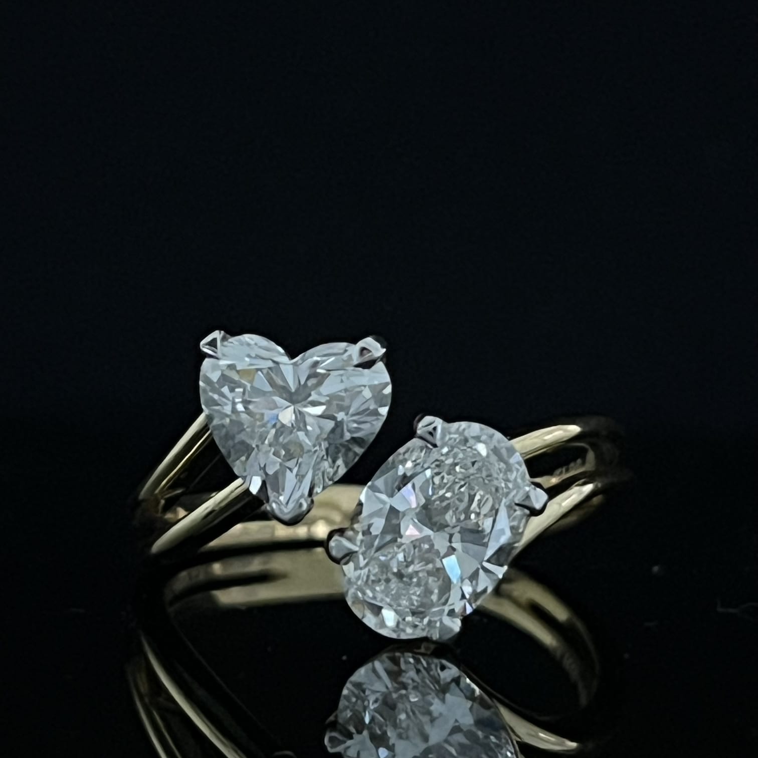 Gold ring with 1.9 carat diamond stone on reflective surface
