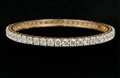 10.27 carat round shaped diamond bangle in 18K gold on black background
