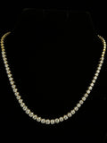 Gold necklace with small round diamonds in 14K on black background showing detail
