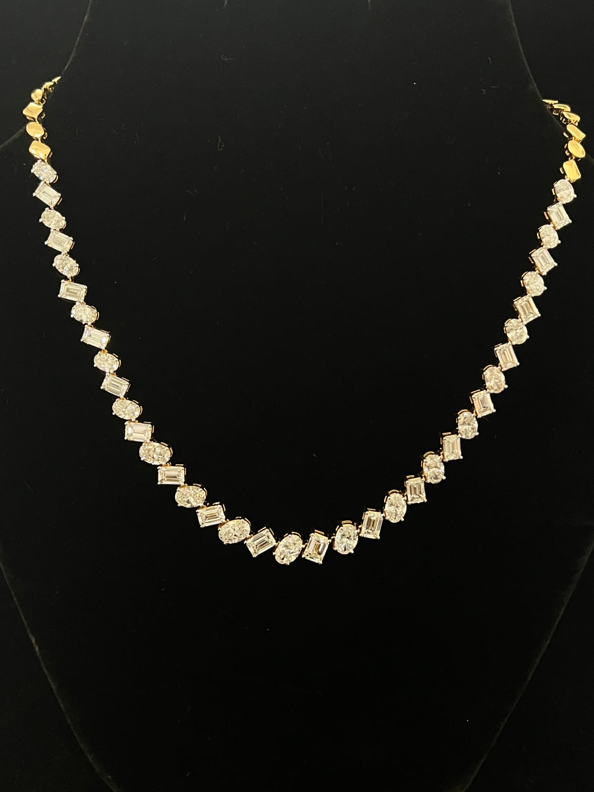 Elegant gold necklace with multiple diamond stones 14K purity on black background
