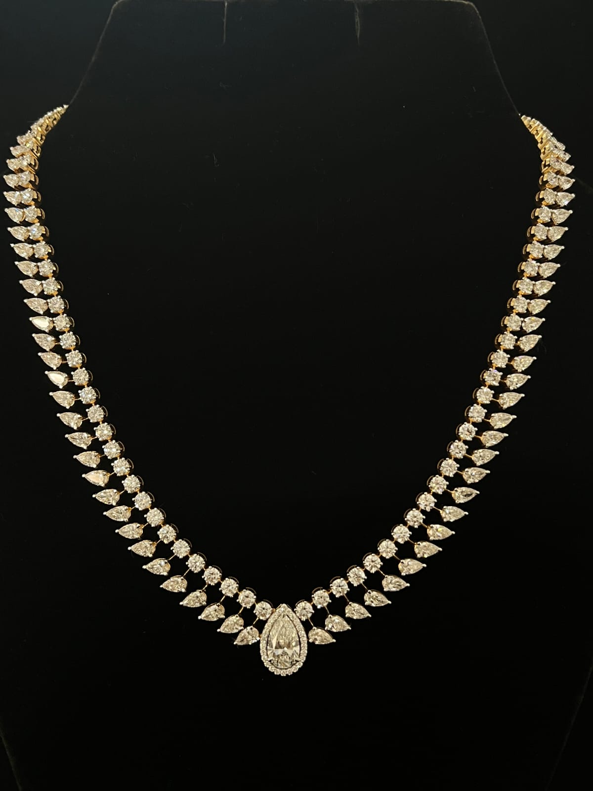 Ornate gold necklace with diamond accents 14K purity on black background
