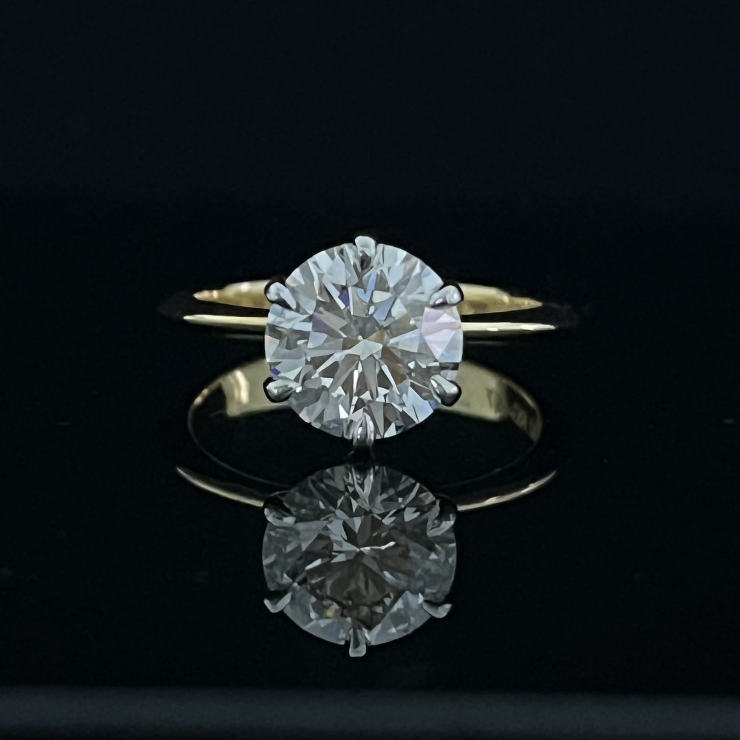 Gold ring with a large diamond on a black background