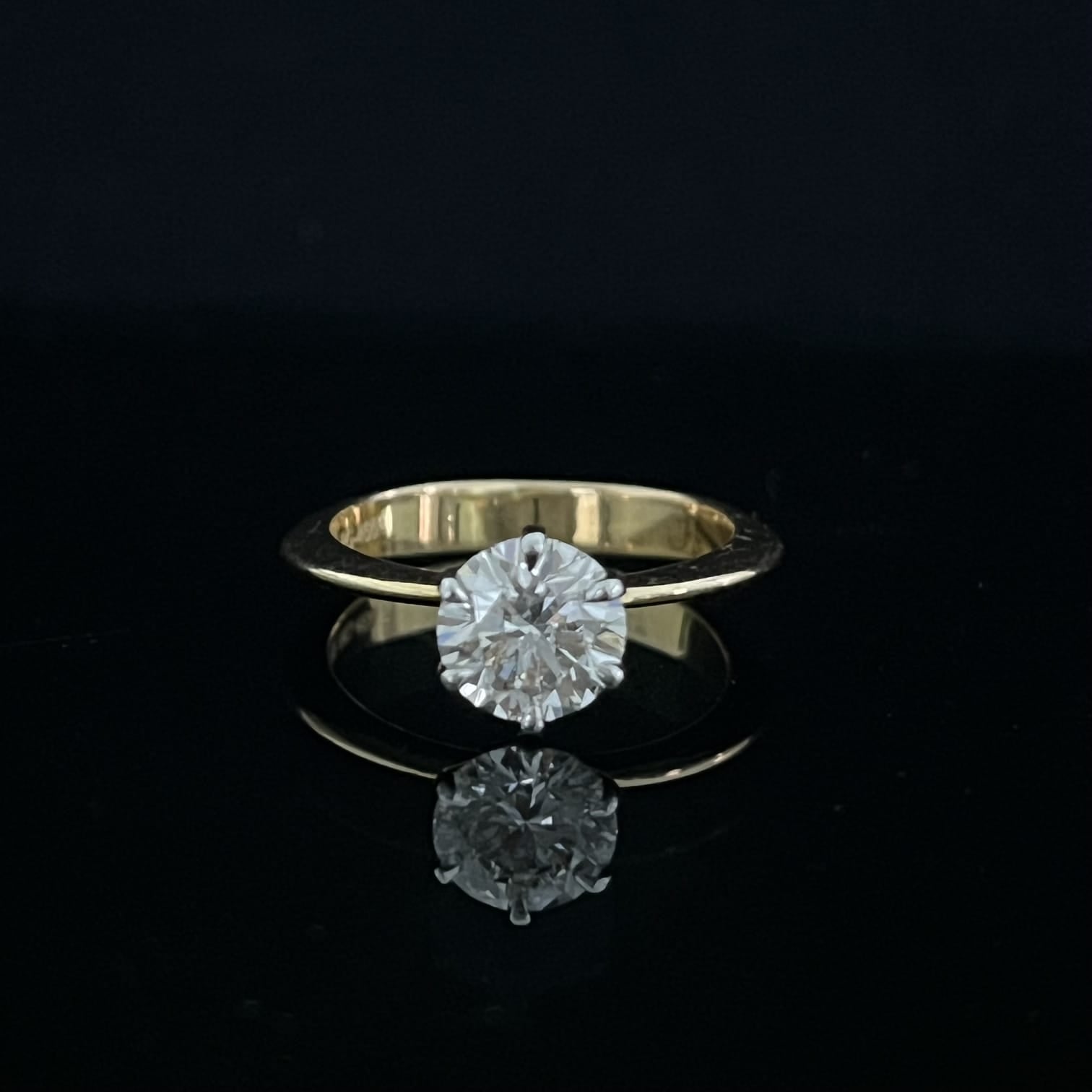 Gold ring with a diamond on a black background