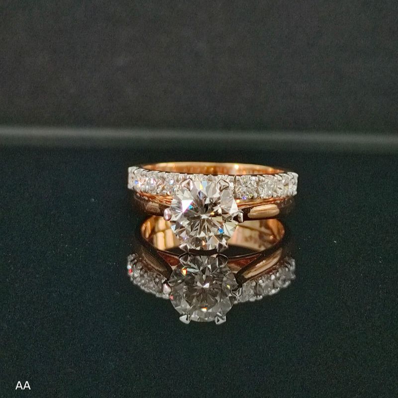 Rose gold ring with diamonds on a reflective surface