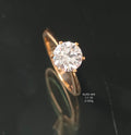 Gold ring with a large diamond on a dark background